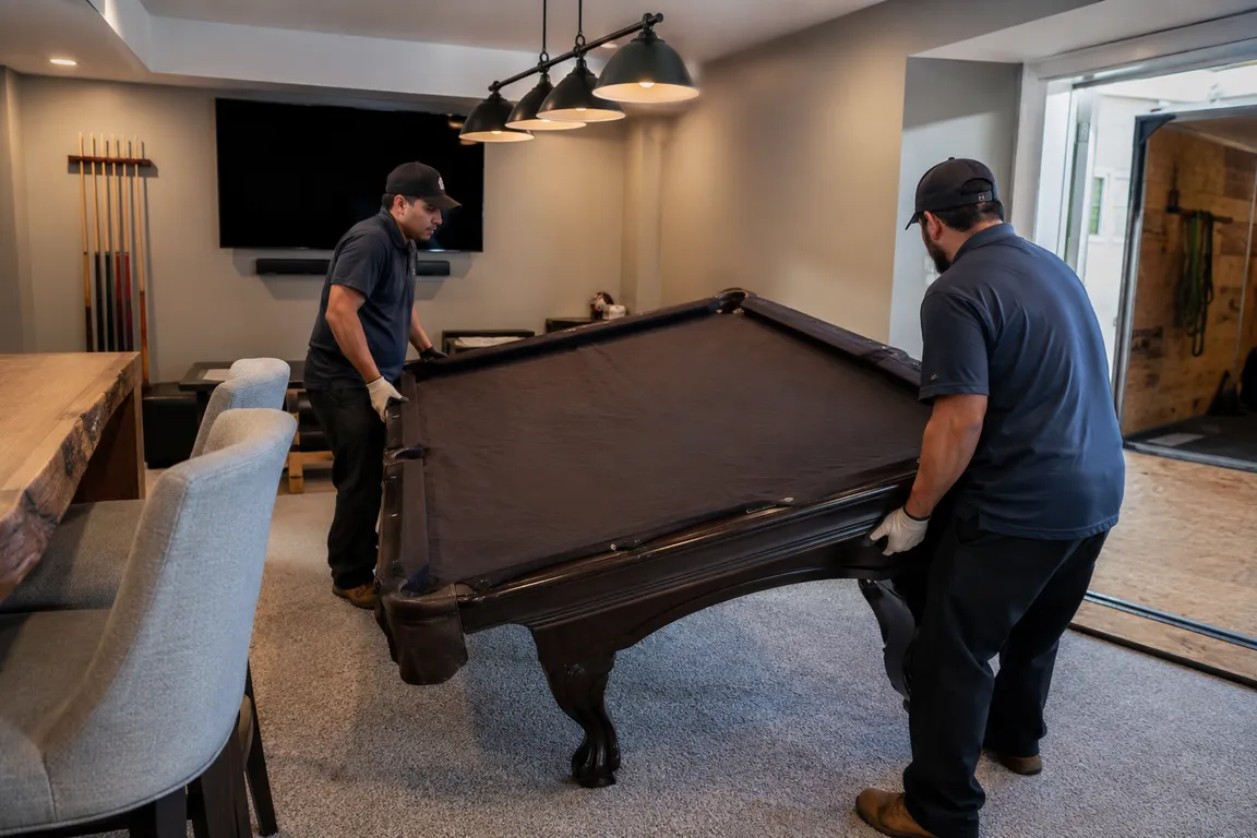Crew safely removing a pool table from a property
